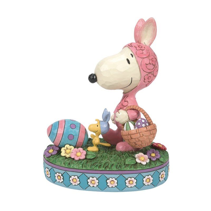 Snoopy in een roze konijnenpak, Woodstock en paaseieren in een mandje.
