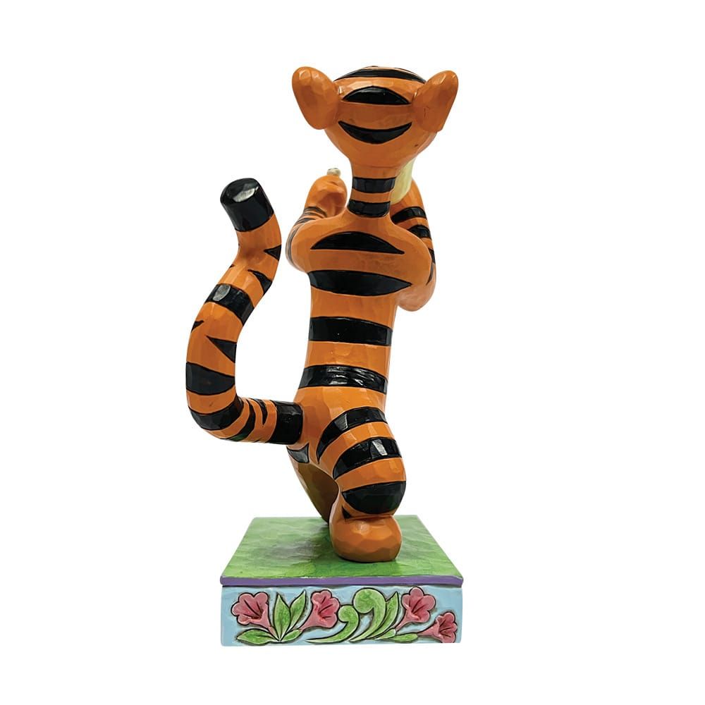 Tigger-figuurtje staand op een sokkel, armen omhoog. Oranje met zwarte strepen, beschilderde bloemen en groene sokkel.