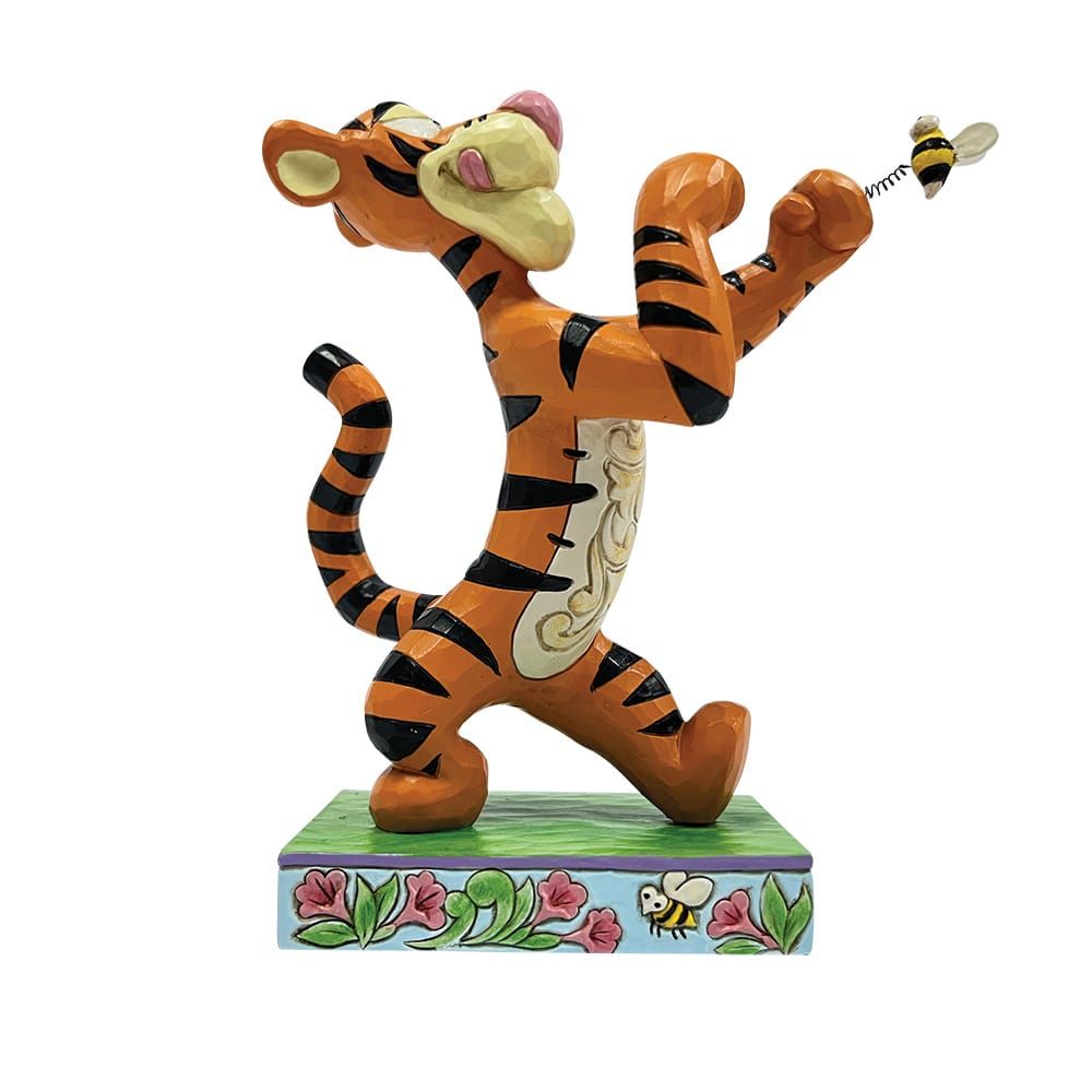 Tigger-figuurtje dat naar een bij reikt. Oranje en zwarte strepen, lachend, op een versierde sokkel.