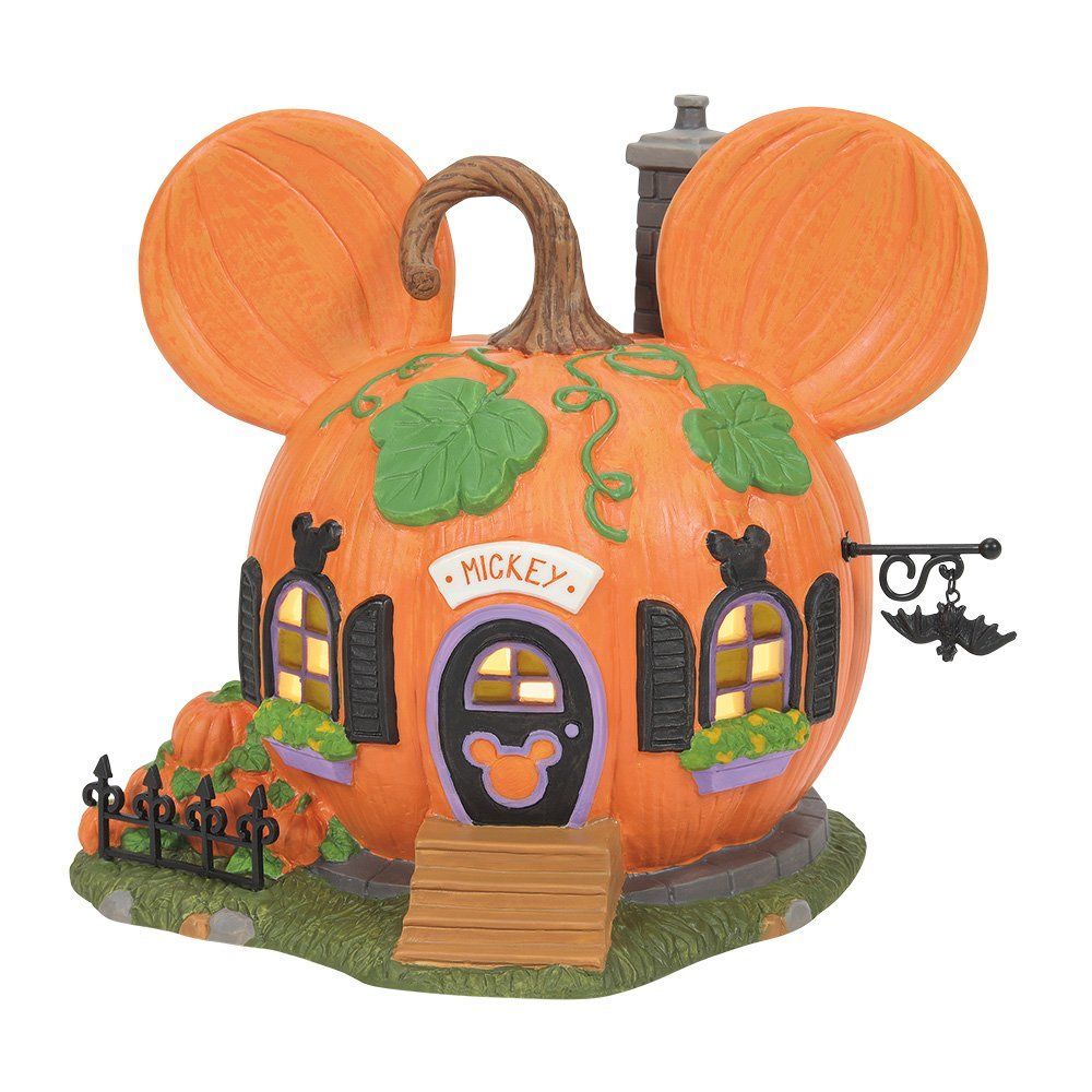 Een pompoenhuis in de vorm van Mickey Mouse met zwarte luiken, een vleermuisbord en een stenen sokkel.
