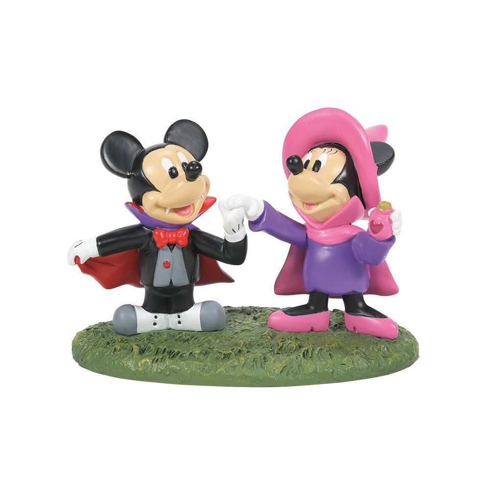 Mickey Mouse en Minnie Mouse in Halloweenkostuums, hand in hand. Mickey als vampier, Minnie met heksenhoed en cape.