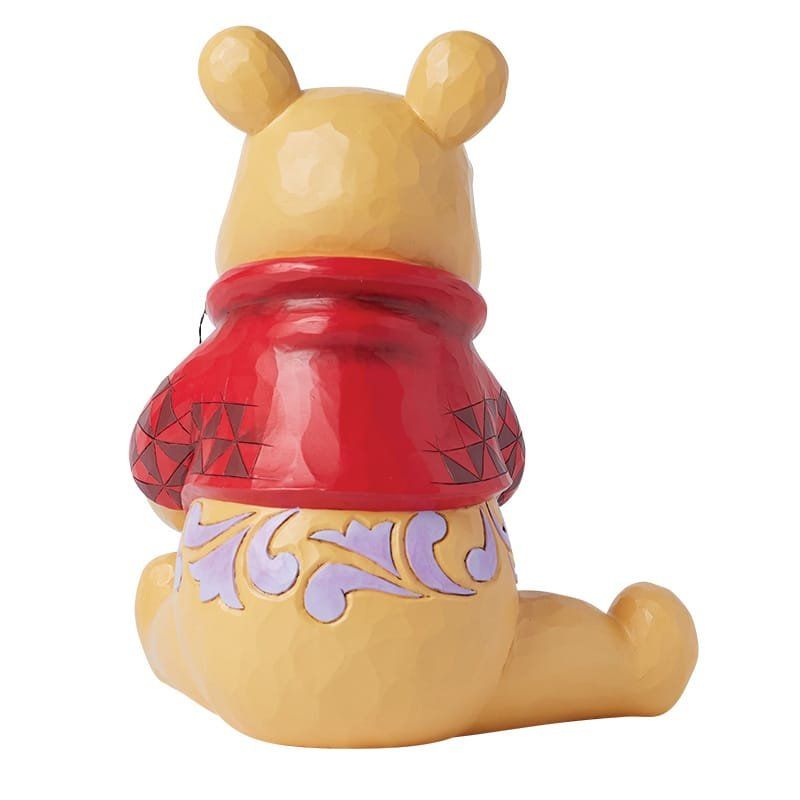 Winnie de Pooh-figuurtje, achterkant. Gele beer in een rood shirt met decoratieve paarse bloemenaccenten.