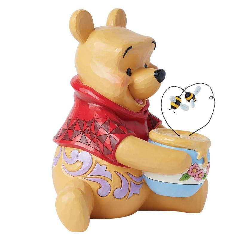 Winnie de Pooh-figuurtje met honingpot en bijen, lachend. Geel, rood, blauw en roze.
