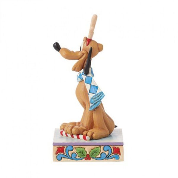 Een Pluto-beeldje met een blauwe sjaal, dat naar boven kijkt, een bot vasthoudt en op een versierde sokkel staat.