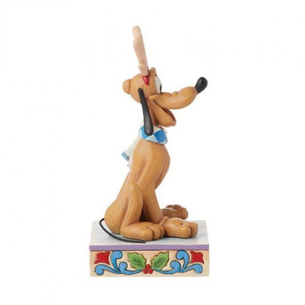 Een Pluto-beeldje met gewei en sjaal, zittend op een versierde sokkel met een zuurstok.