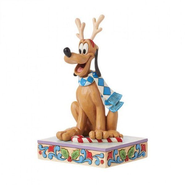 Een Pluto-beeldje met gewei en sjaal, zittend op een versierde sokkel met een zuurstok.