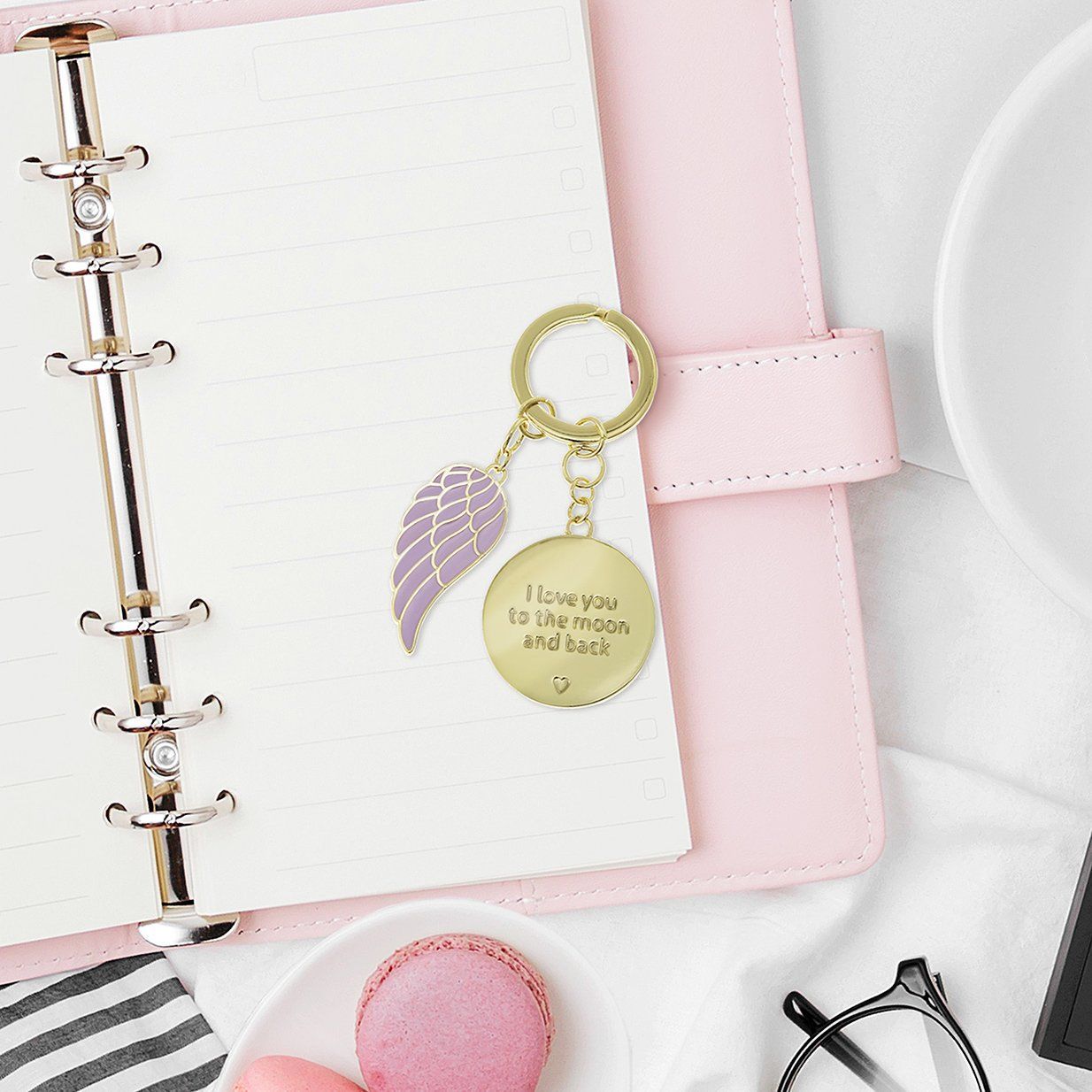 Roze agenda met een gouden sleutelhangertje met een vleugel en een hangertje met de tekst