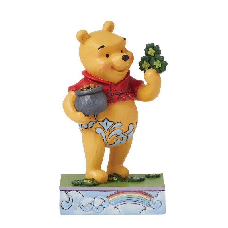 Winnie de Poeh houdt een pot met goud en klavertjes vier vast, op een voetstuk met een regenboog.