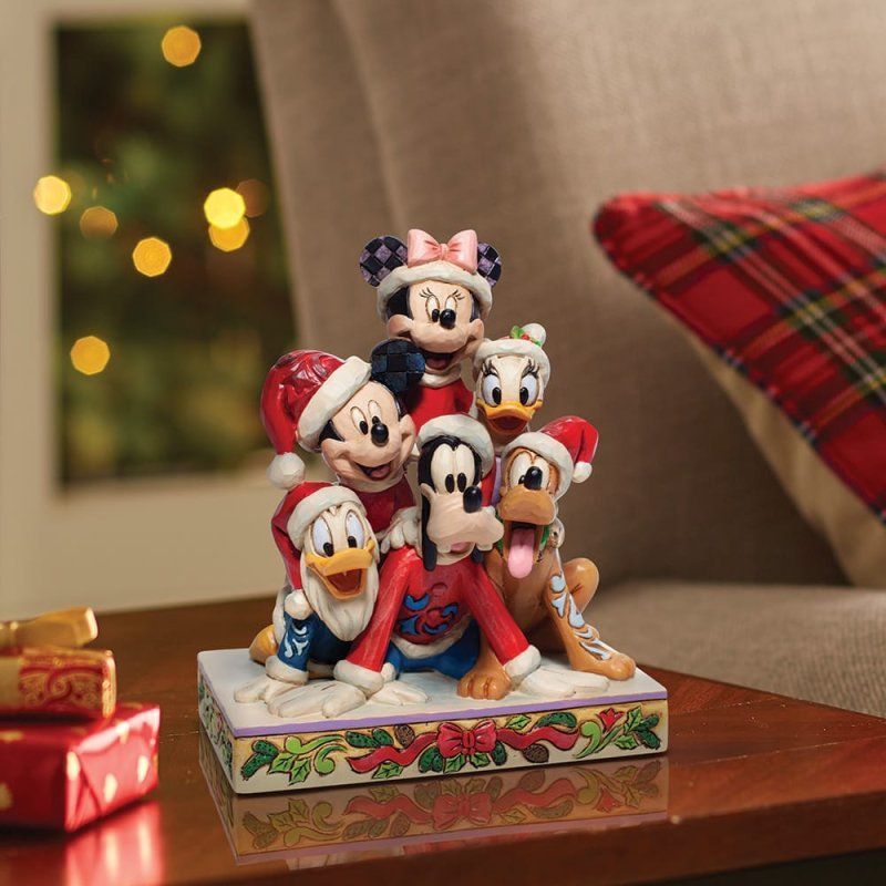 Disneyfiguren met kerstmutsen, een sneeuwlandschap, cadeaus op tafel.