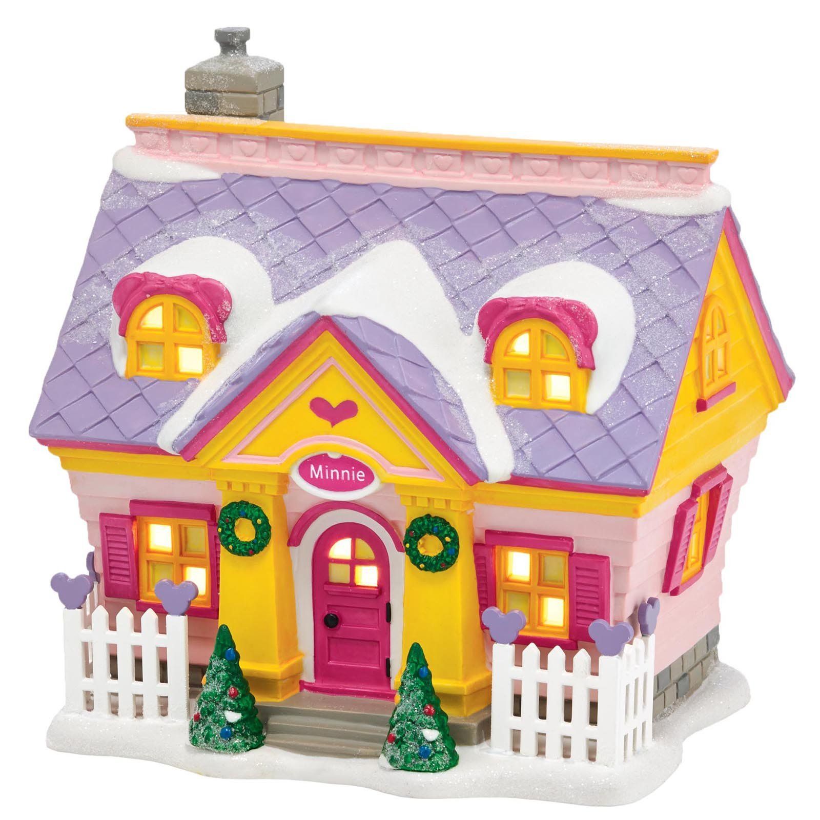 Kerstdorpje met huisje, roze en geel, paars dak bedekt met sneeuw, kransen en lichtjes.