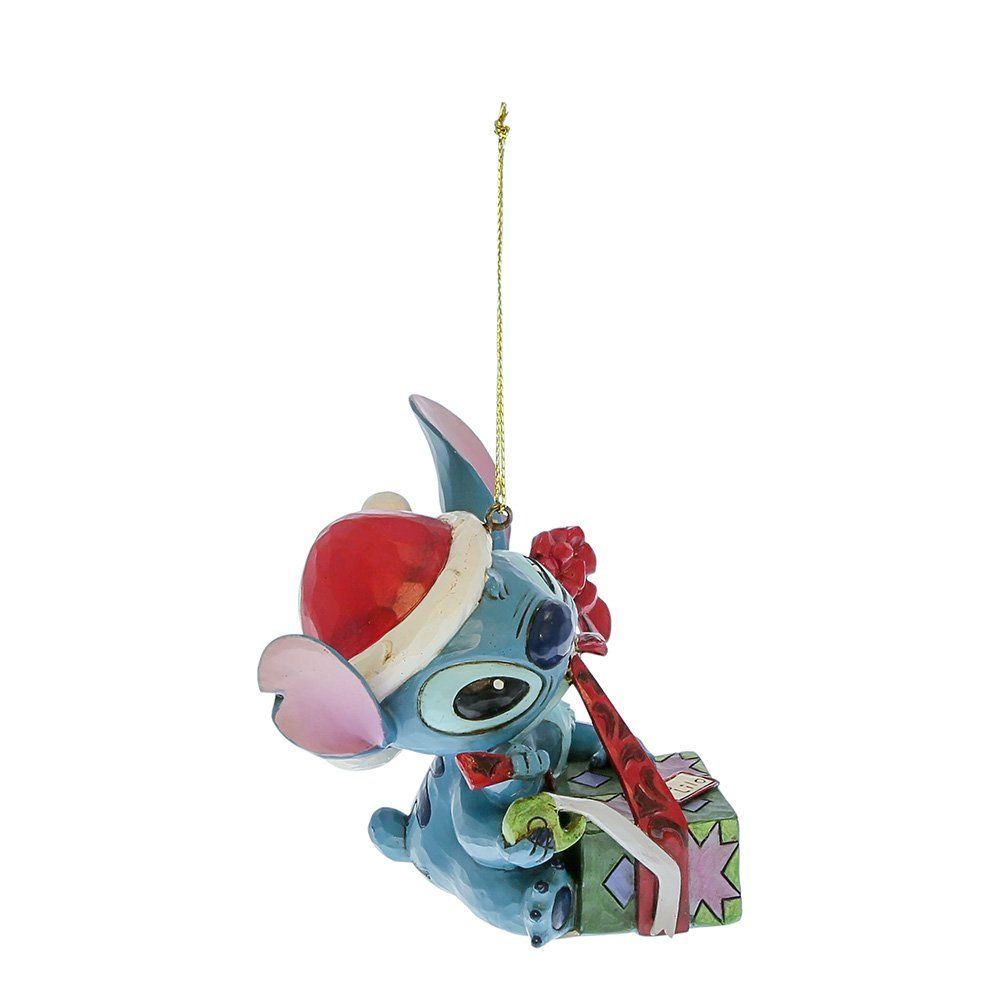 Een kerstornament van Stitch dat een cadeautje vasthoudt; het draagt ​​een kerstmuts en een strik.