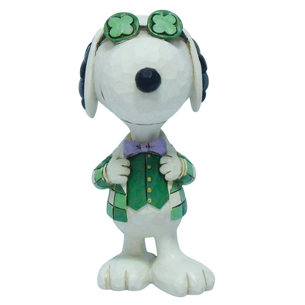 Een Snoopy-figuurtje met klaverbril, groene jas en paarse vlinderdas, staand.