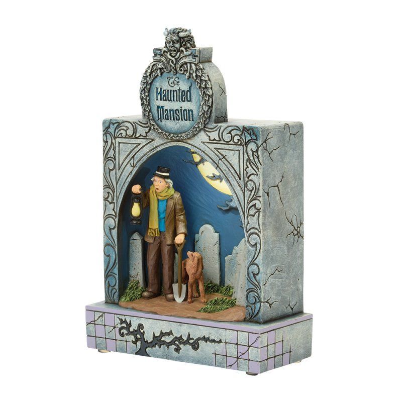 Disney's Haunted Mansion-figuurtje: een man met hond, lantaarn en schop in een grafachtig bouwwerk. Nachtscène.