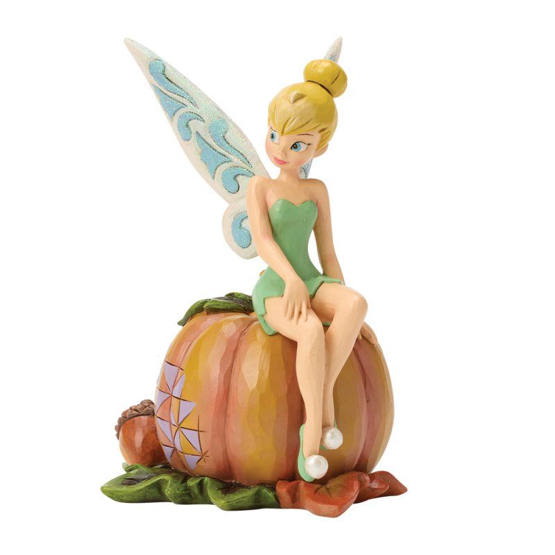 Een Tinkerbell-figuurtje in een groene jurk, zittend op een pompoen, met lichtblauwe vleugels en herfstkleuren.