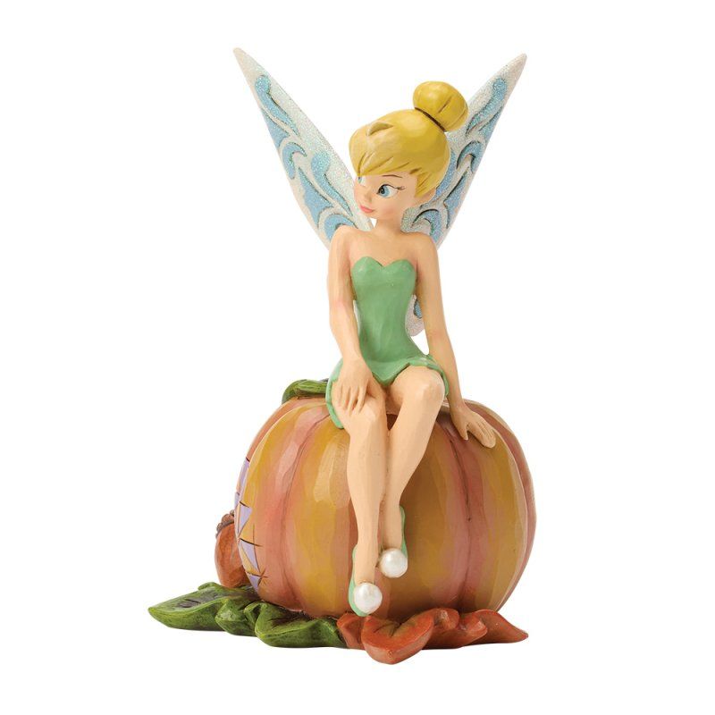 Een Tinkerbell-figuurtje in een groene jurk, zittend op een pompoen met groene bladeren; witte vleugels.