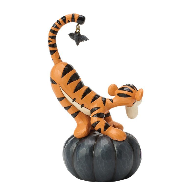 Tigger zat op een zwarte pompoen en reikte naar een vleermuisvormig bedeltje.