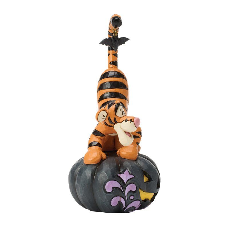 Tigger zit bovenop een zwarte pompoen, met een vleermuis op zijn staart.