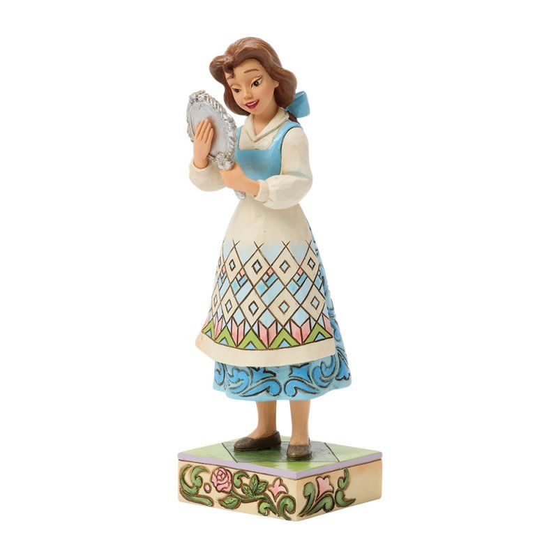 Beeldje van een vrouw in een kleurrijk schort die in een spiegel kijkt, staande op een met bloemen versierde sokkel.