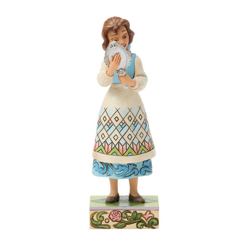 Beeldje van een vrouw in een kleurrijk schort die in een spiegel kijkt, staande op een met bloemen versierde sokkel.