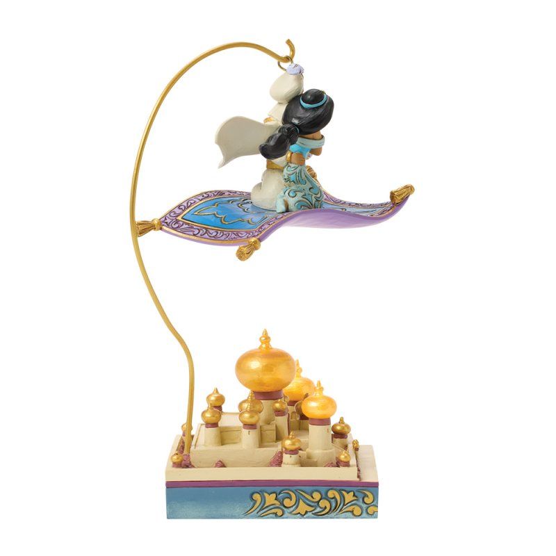 Aladdin en Jasmine vliegen op een magisch tapijt boven een paleis. Goud, blauw en paars domineren het tafereel.