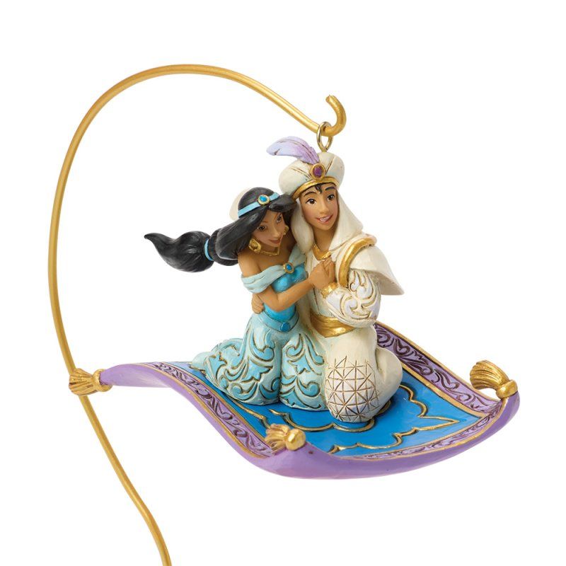 Aladdin en Jasmine op een magisch tapijt boven een gedetailleerd paleisbeeld, ondersteund door een gebogen gouden staaf.