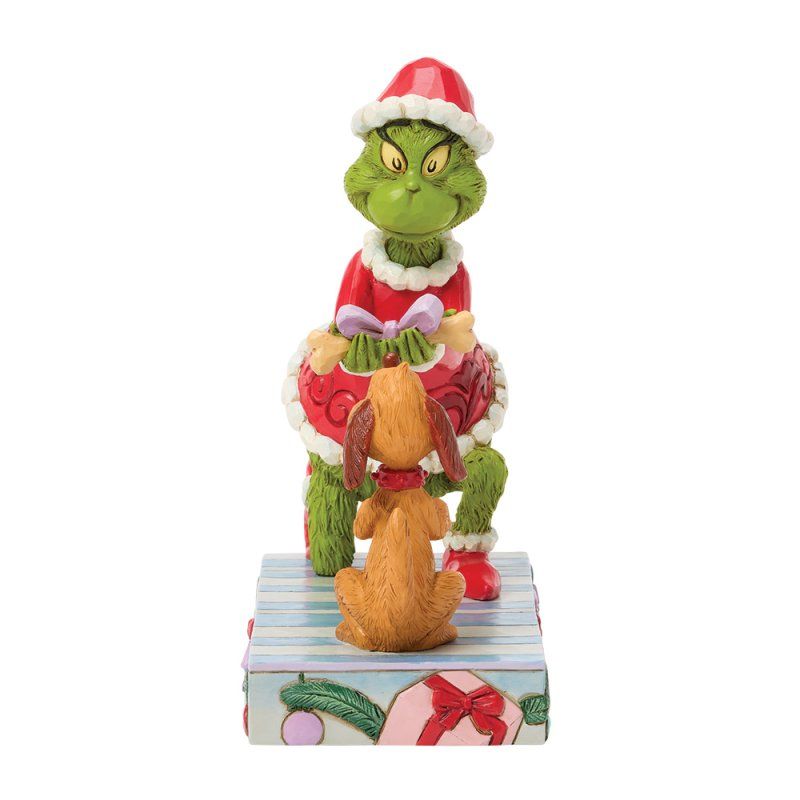De Grinch in een kerstmanpak met zijn hond, op een geschenkdoos.