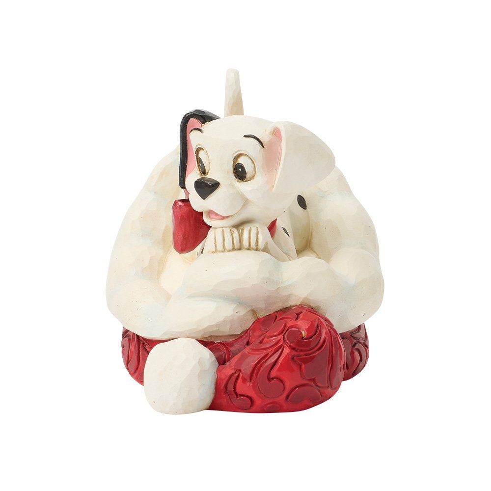 Dalmatiërpuppyfiguurtje op een rood kussen, die iets vasthoudt, met een klein zwart oortje.