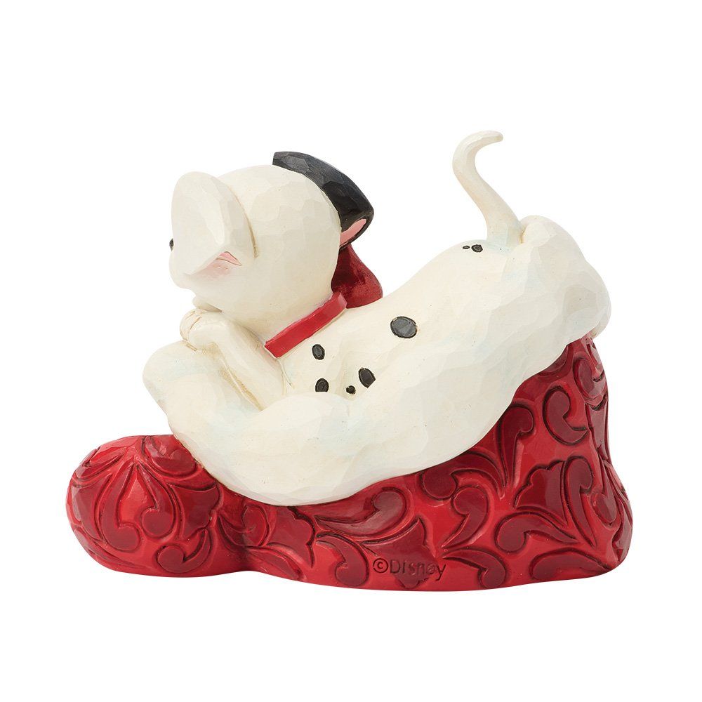 Dalmatiërpuppy in een rood-witte kerstsok, witte hond met zwarte vlekken en rode halsband.