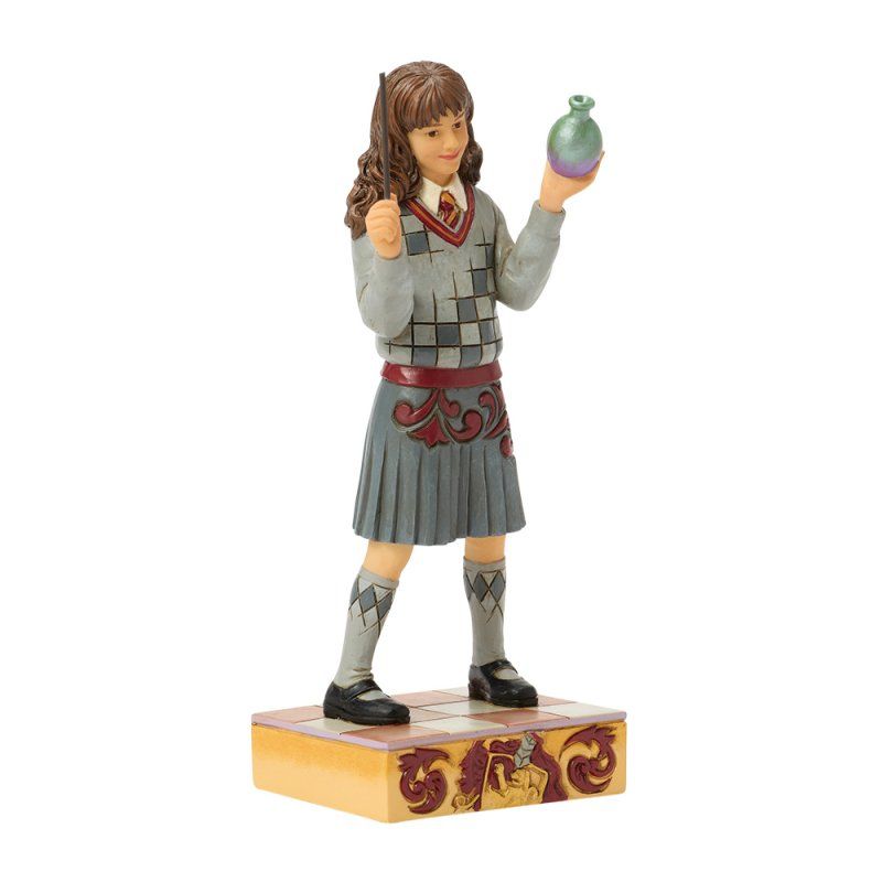 Standbeeld van Hermione Granger met een toverstaf en een toverdrank in haar hand, gekleed in een Griffoendor-uniform.