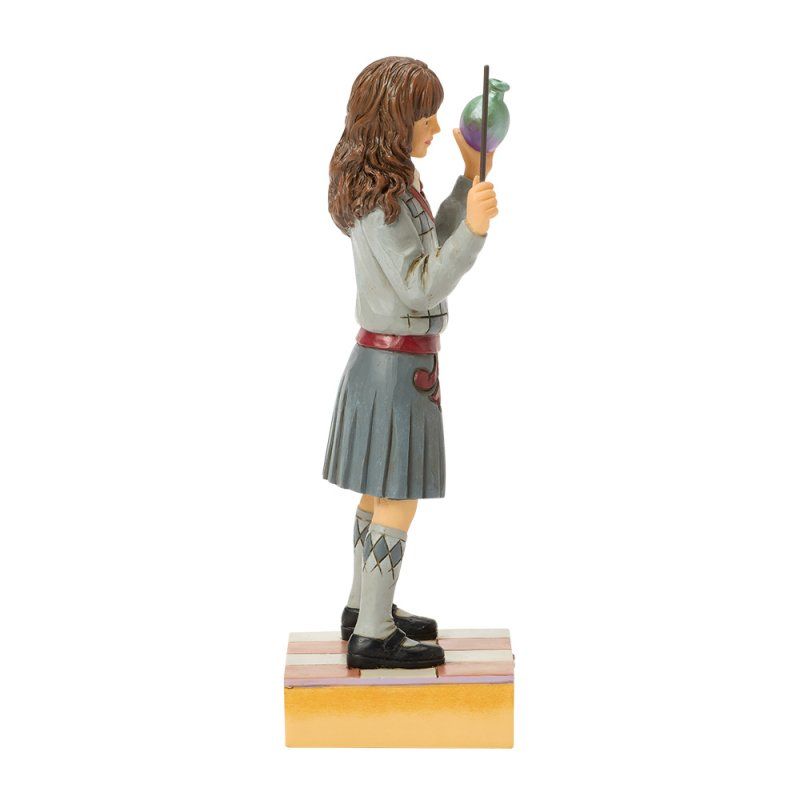 Een beeldje van Hermione Granger met een toverstaf en een toverdrank, gekleed in schooluniform.