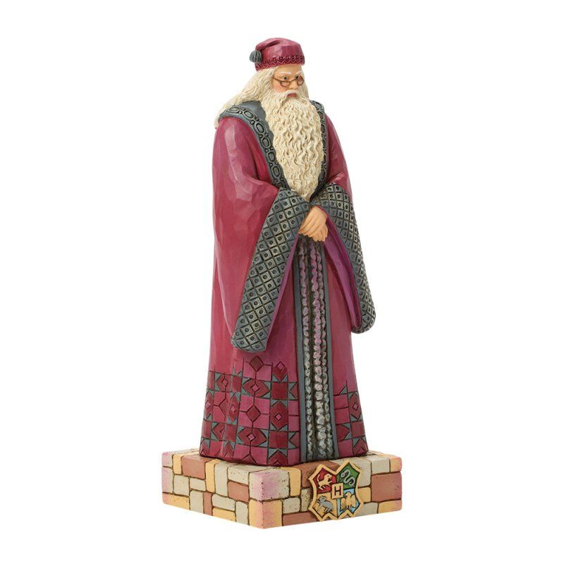 Standbeeld van Dumbledore in bordeauxrode gewaden, staande op een bakstenen sokkel met het wapen van Zweinstein.