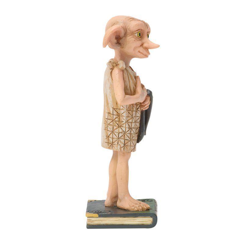 Standbeeld van Dobby de huiself, met een sok in zijn hand, op een boek. Beige tinten, staand profiel.