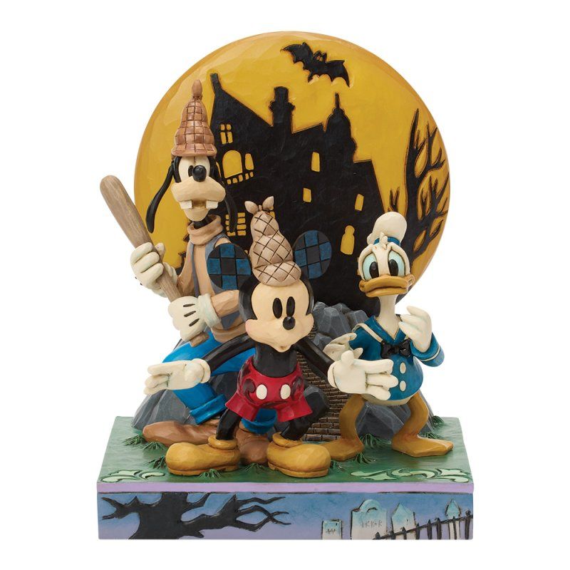 Disney-figuurtjes van Goofy, Mickey en Donald Duck in Halloweenkostuums, voor een silhouet van een spookhuis.