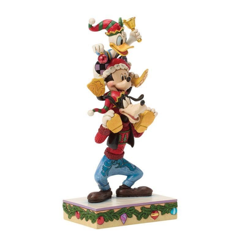 Een kerstfiguurtje van Goofy, Mickey en Donald. Goofy balanceert de anderen, die allemaal feestelijke hoedjes dragen.