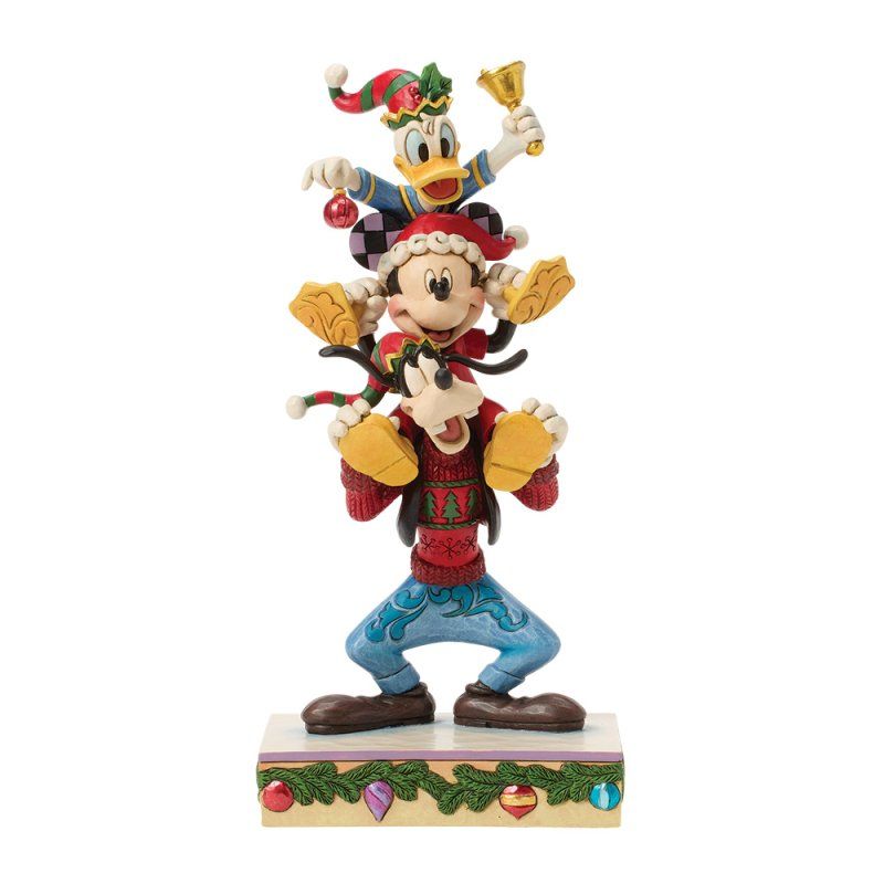 Disney kerstfiguurtje: Goofy die Mickey en Donald vasthoudt, met versierde sokkel.