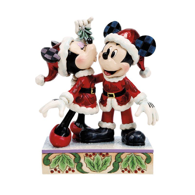 Mickey en Minnie Mouse in kerstmanpakjes kussen elkaar onder een maretak, staand op een versierde sokkel.