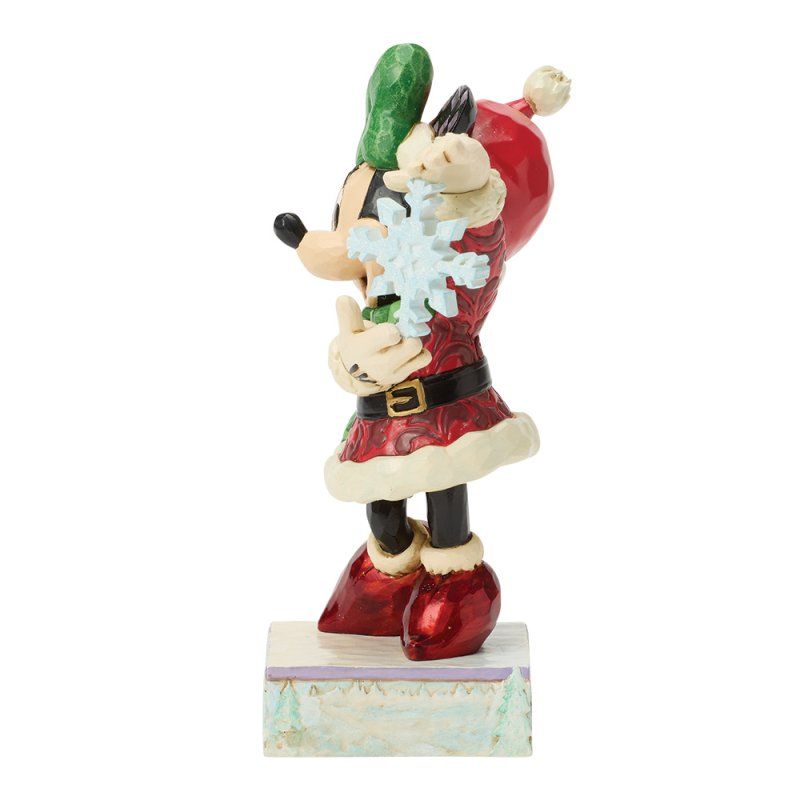 Minnie Mouse in een kerstoutfit met een sneeuwvlokje in haar hand. Rode en groene kleuren. Lachend.
