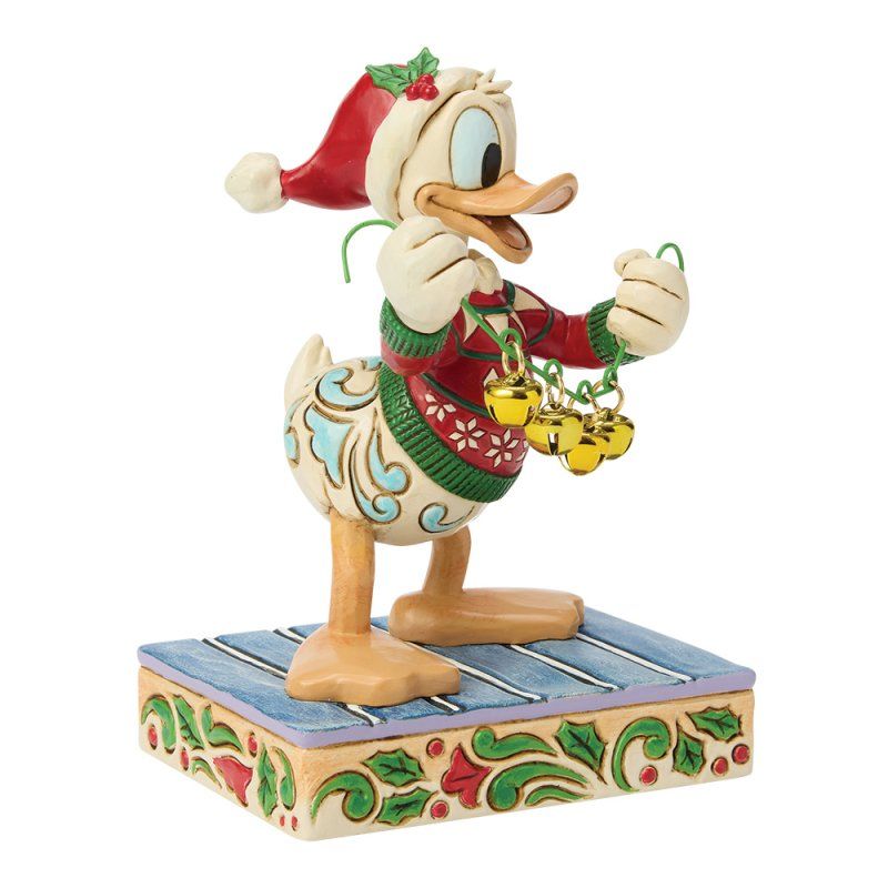 Een figuur van Donald Duck met een kerstmuts op en belletjes in zijn hand, op een blauw, bedrukt platform.