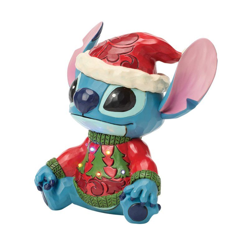 Een Stitch-figuurtje met een kerstmuts en een kersttrui aan.