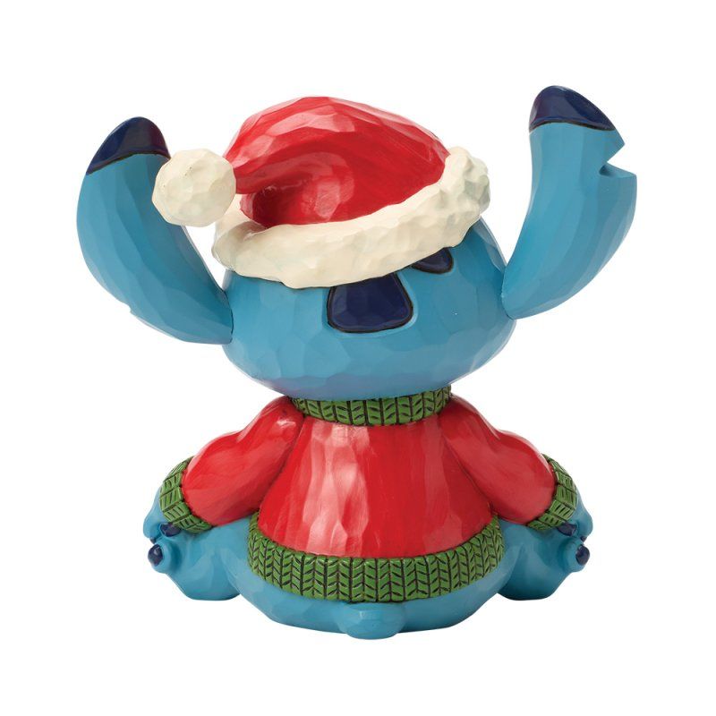 Een Stitch-figuurtje met een kerstmuts en een rode trui, met de armen omhoog.