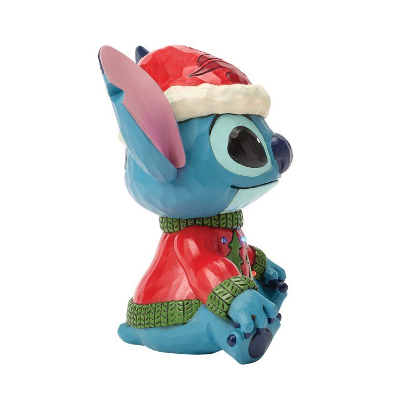 Een Stitch-figuurtje met een kerstmuts en een rode trui.
