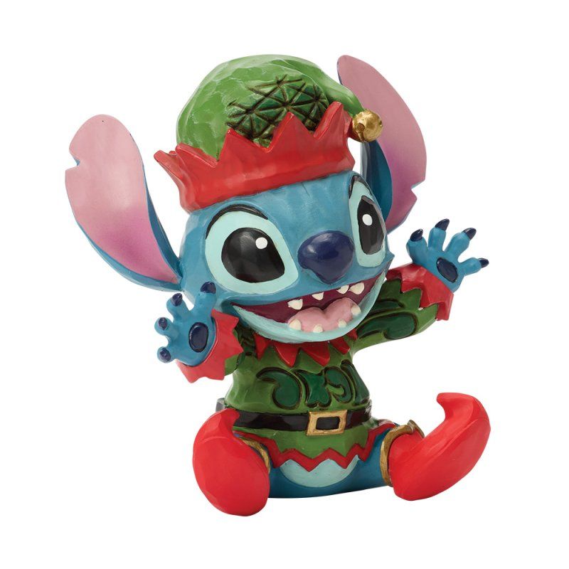 Stitch, verkleed als elf, lachend, met een groene hoed, rode laarzen en een rode kraag.