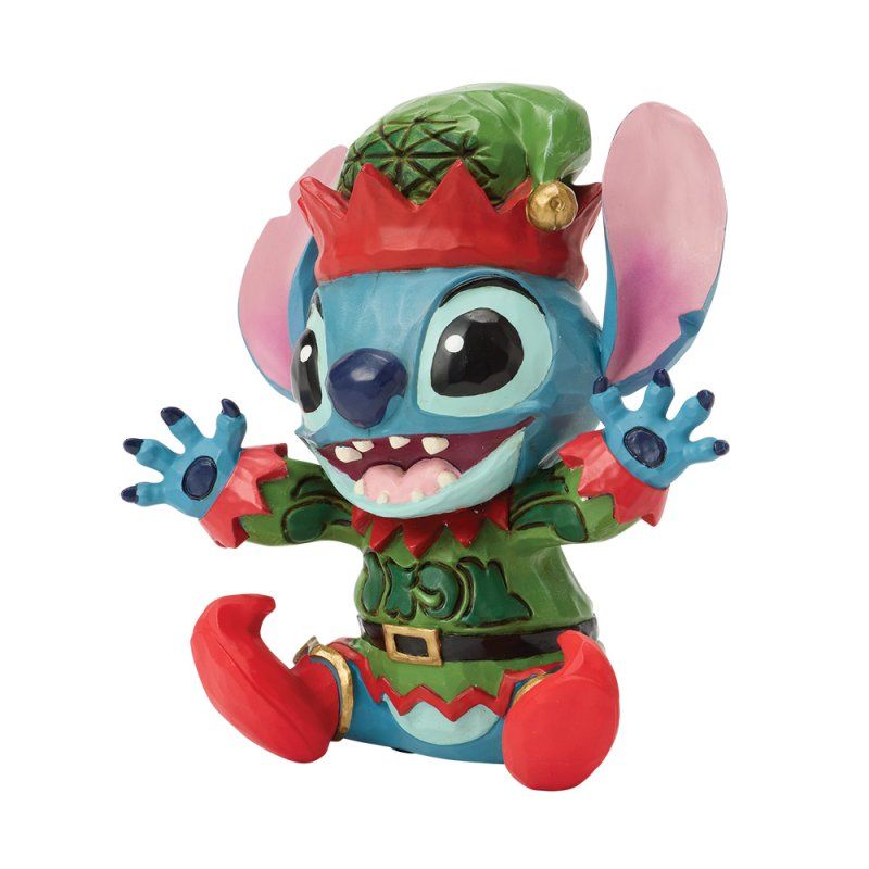 Een Stitch-figuurtje in elfenkleding in rode en groene kleuren, met een lachend gezicht.