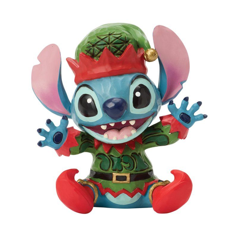 Stitch, verkleed als elf, lachend, met een groene hoed, rode laarzen en een rode kraag.