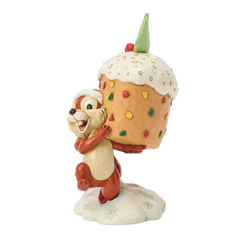 Een eekhoorn houdt een gigantische cupcake vast met kleurrijke versieringen; de ondergrond is besneeuwd.