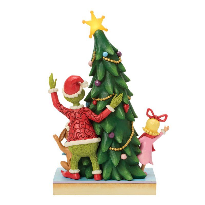 De Grinch en Cindy Lou Who versieren een kerstboom, samen met een hond, tegen een witte achtergrond.
