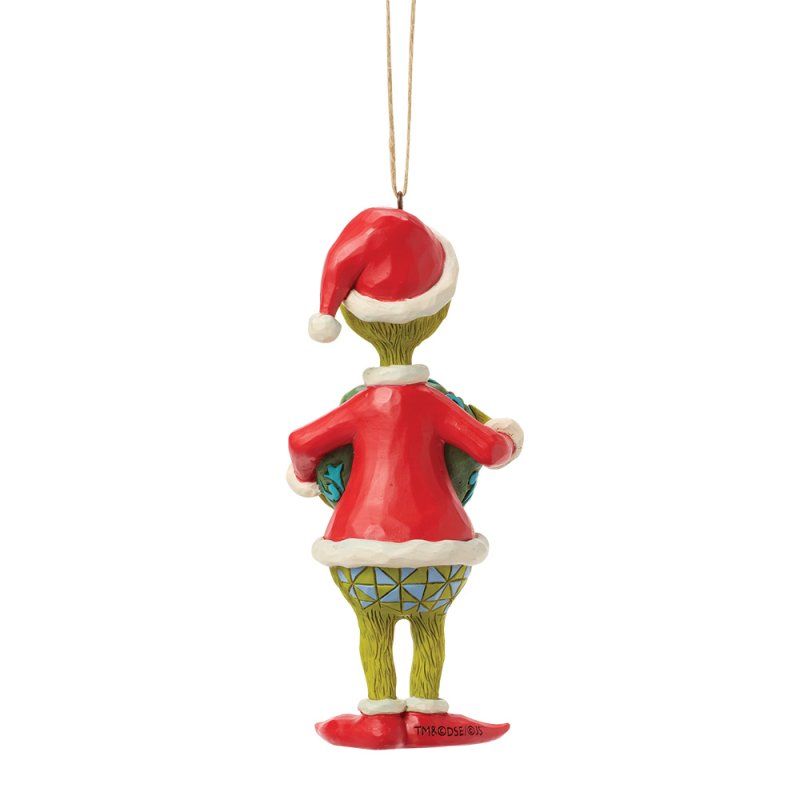 Een kerstornament van de Grinch in een kerstmanpak, met een cadeautje in zijn hand.