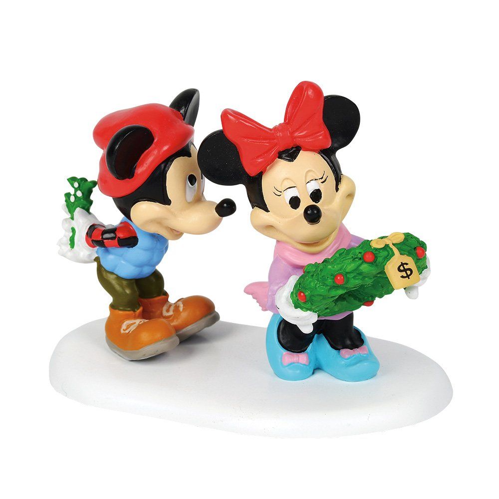 Mickey en Minnie Mouse in winterkleding staan op een besneeuwde ondergrond; Mickey kust Minnie, die een krans vasthoudt.
