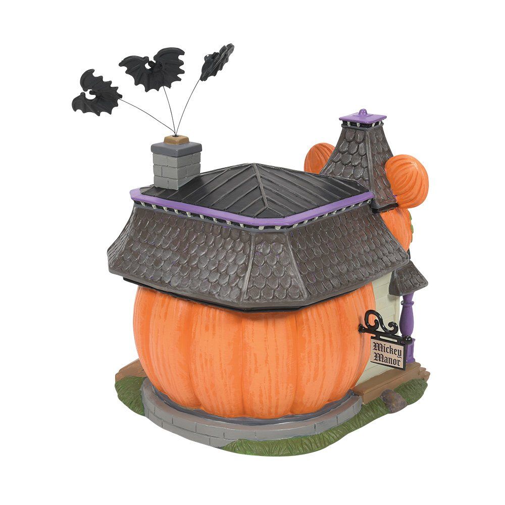 Een Halloweenhuis in de vorm van pompoenen met vleermuizen erboven.