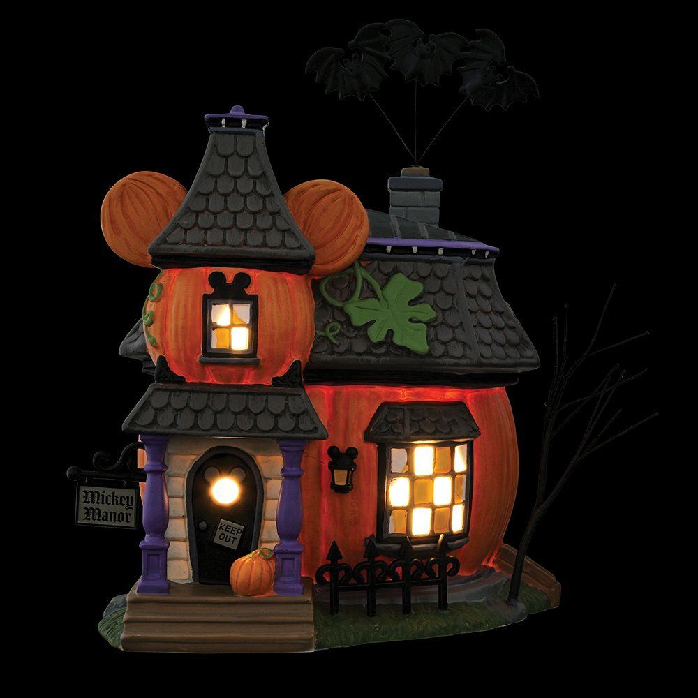 Halloween-pompoenhuis met verlichte ramen en een zwart dak.